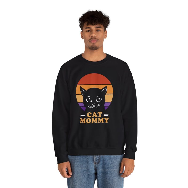 Person wearing a crewneck sweatshirt with a cat face inside red, orange and purple sunset stripes above warm orange lettering printed on the front