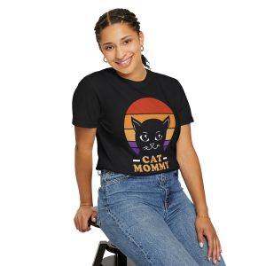 Person wearing a tee with a cat face inside red, orange and purple sunset stripes above warm orange lettering printed on the front