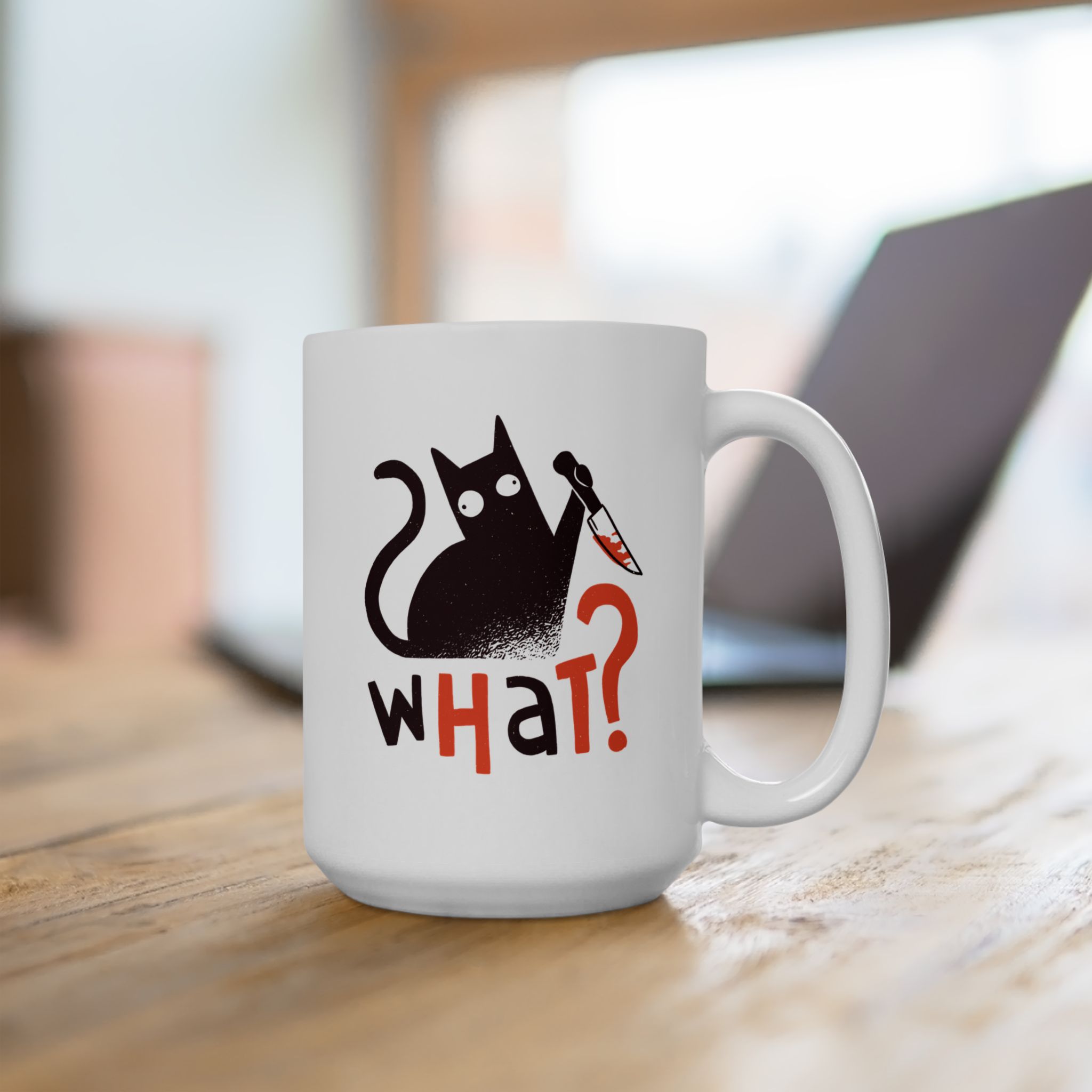 White ceramic mug showing a wide-eyed black cat with a kitchen knife and black and orange lettering