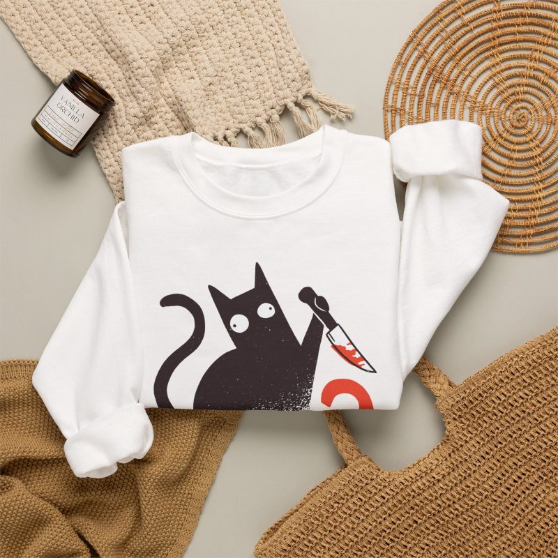 Wide-eyed black cat with a curled tail and kitchen knife beside black and orange WHAT? lettering in the front print