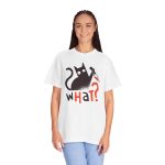 Person wearing a tee showing a wide-eyed black cat with a kitchen knife and black and orange lettering on the front