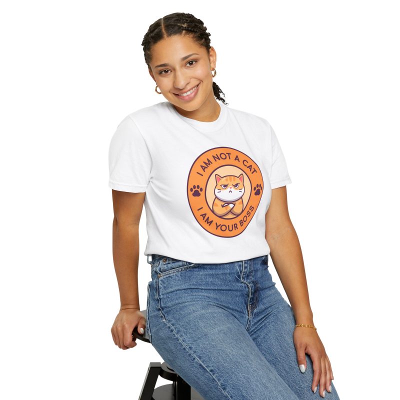 Person wearing a tee with an unimpressed ginger tabby with crossed arms inside an orange badge with dark purple lettering and two paw prints printed on the front