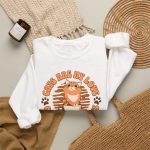 Detail of the sweatshirt's orange tabby, cream coffee cup and circular Cats Are My Love lettering