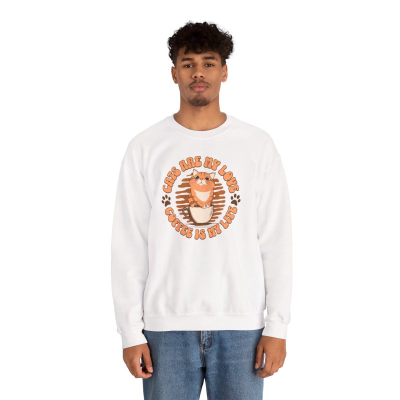 Person wearing a white crewneck sweatshirt with an orange tabby and coffee graphic