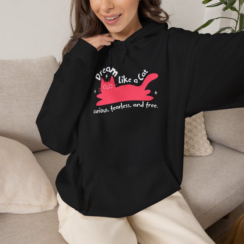 Person wearing a hoodie with a pink reclining cat with a raised tail, round eyes and white sparkles printed on the front