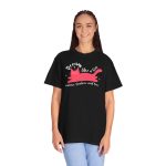 Person wearing a tee with a pink reclining cat with a raised tail, round eyes and white sparkles printed on the front