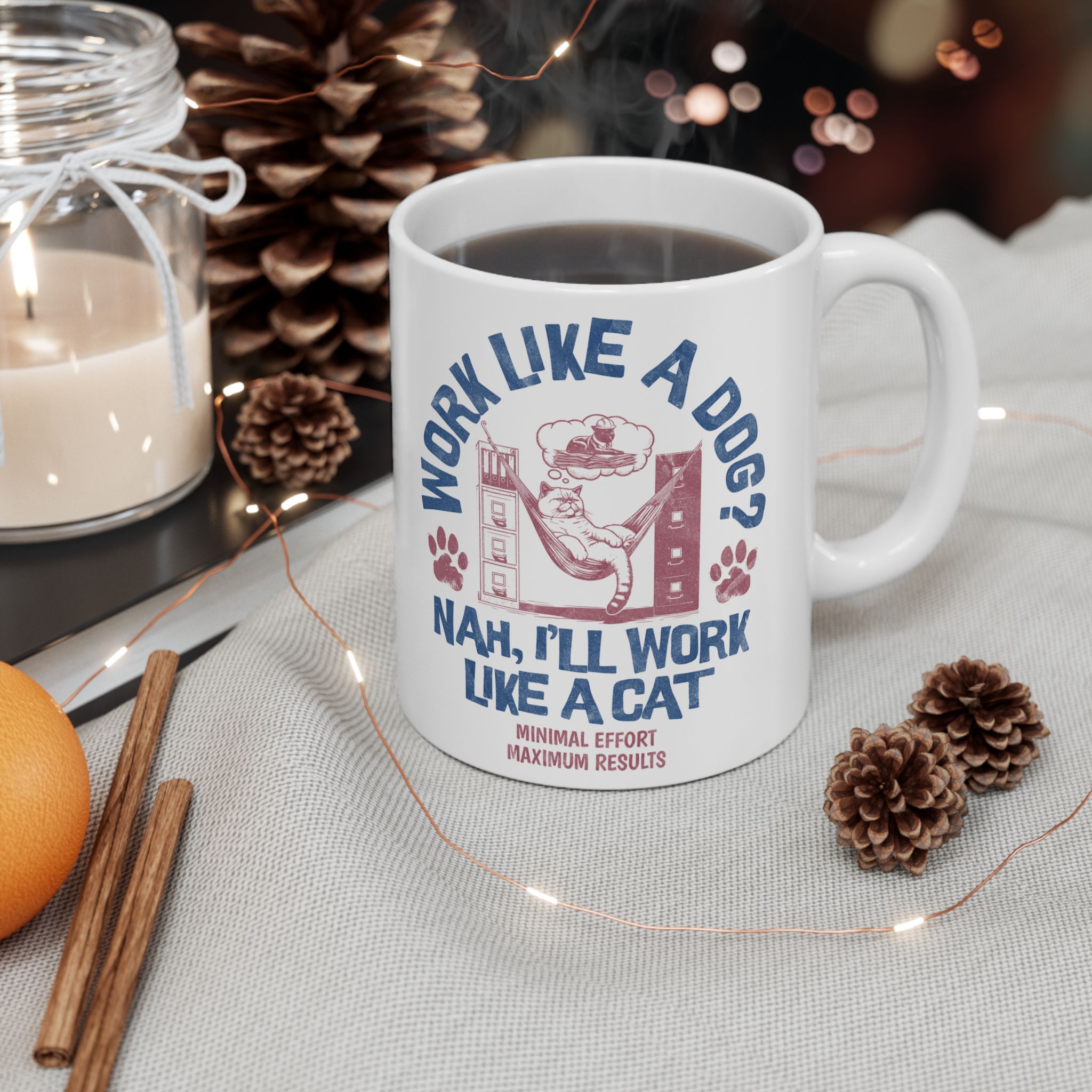 White ceramic mug showing a cat reclining in a hammock between filing cabinets with blue lettering and red paw prints