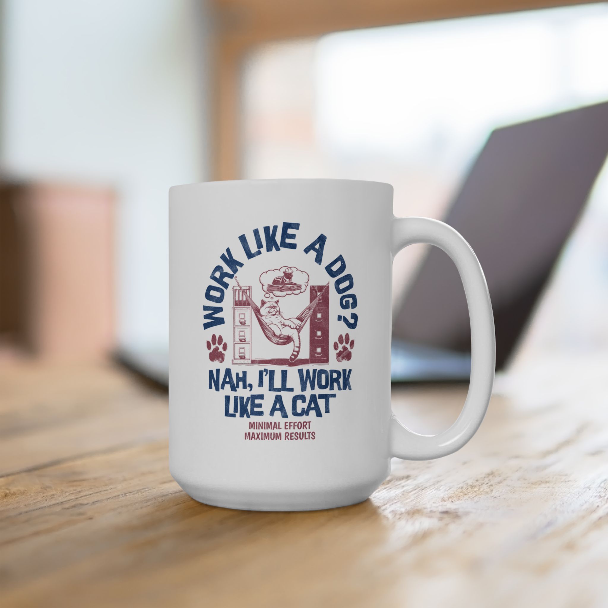 White ceramic mug showing a cat reclining in a hammock between filing cabinets with blue lettering and red paw prints