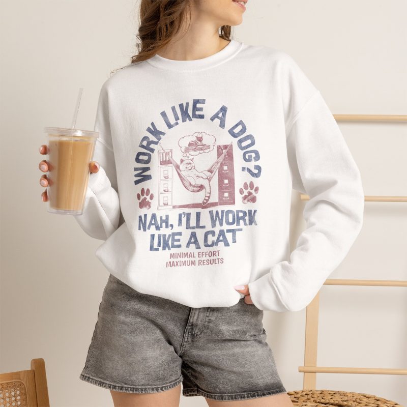 Person wearing a crewneck sweatshirt with a cat reclining in a hammock between filing cabinets with blue lettering and red paw prints printed on the front