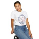 Person wearing a tee with a cat reclining in a hammock between filing cabinets with blue lettering and red paw prints printed on the front