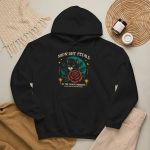 Detail of the black cat with a red rose and golden stars graphic on the hoodie