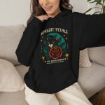 Person wearing the black Midnight Petals cat hoodie on a sofa