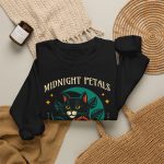 Detail of the black cat with a red rose and golden stars graphic on the crewneck sweatshirt