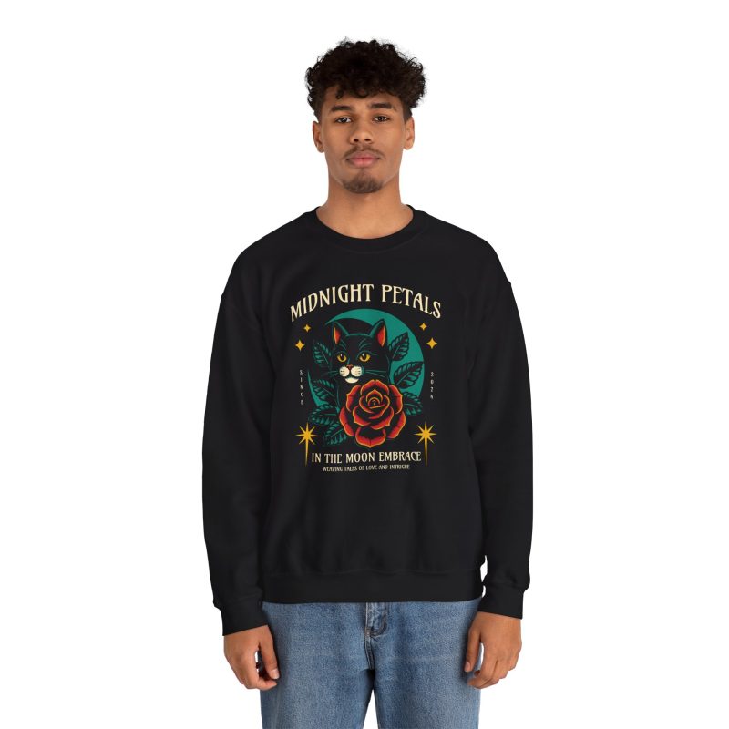 Person wearing a crewneck sweatshirt with a black cat with a red rose and golden stars graphic on the front