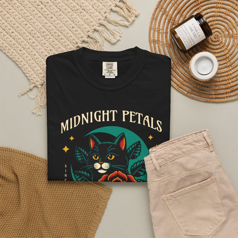 Detail of the black cat with a red rose and golden stars graphic on the tee