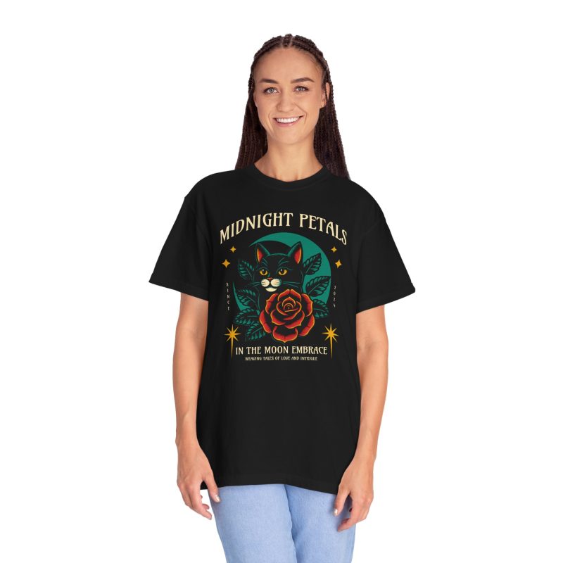 Person wearing a tee with a black cat with a red rose and golden stars graphic on the front