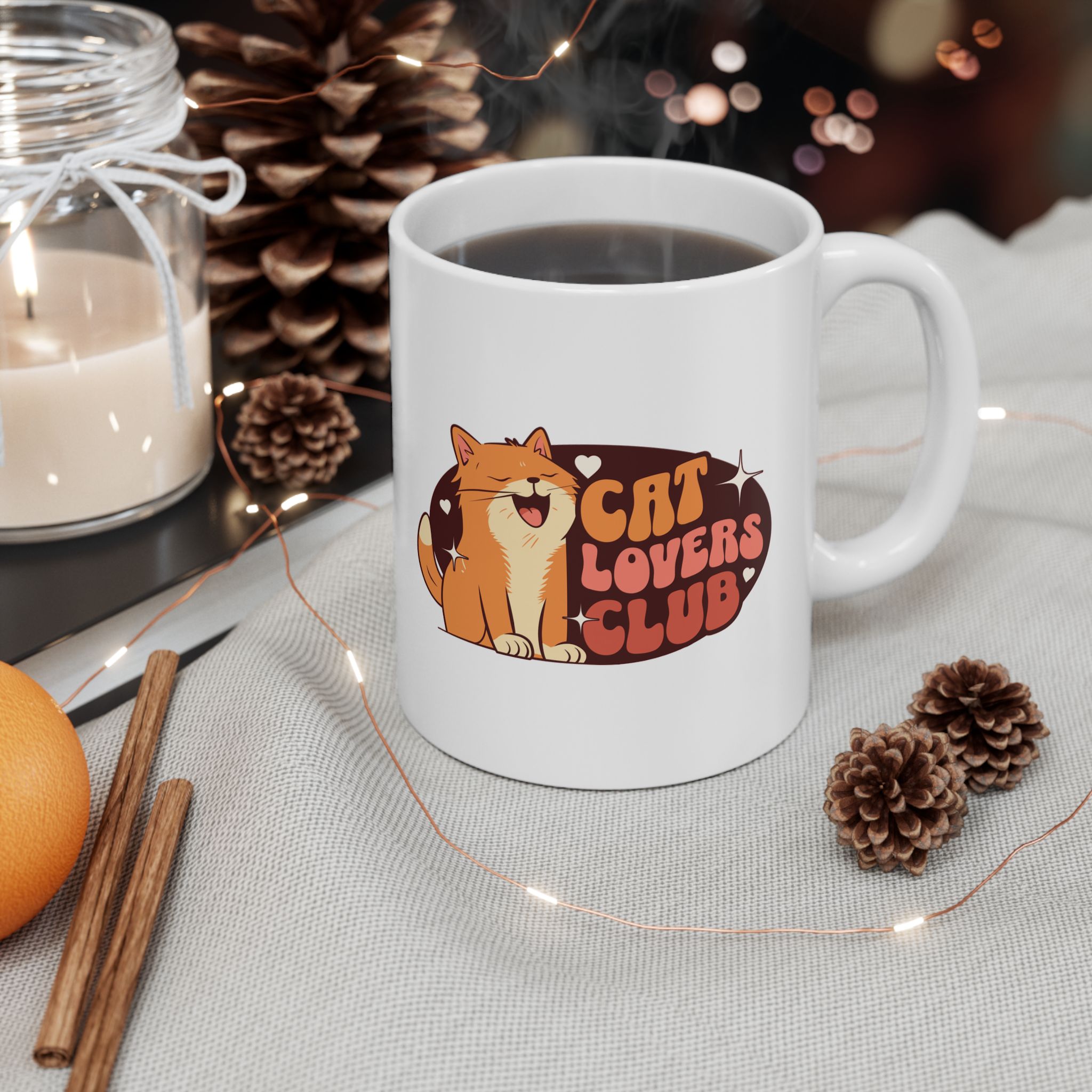 White ceramic mug showing a smiling orange tabby beside retro lettering in an oval badge with hearts and starbursts