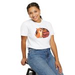 Person wearing a tee with a smiling orange tabby beside retro lettering in an oval badge with hearts and starbursts printed on the front