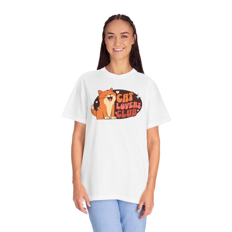 Person wearing a tee with a smiling orange tabby beside retro lettering in an oval badge with hearts and starbursts printed on the front