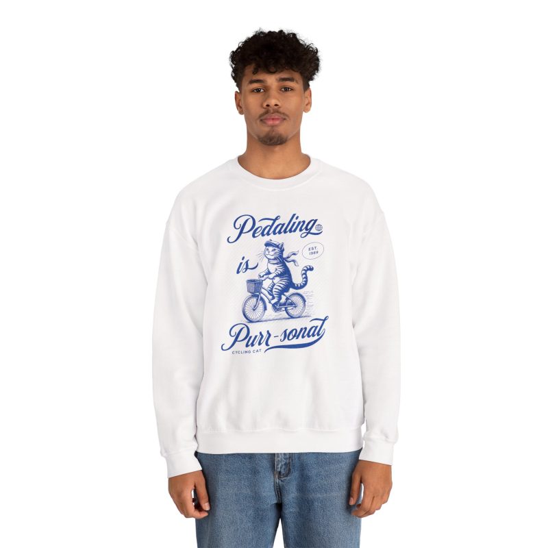 Person wearing a sweatshirt with a blue cat on a bicycle