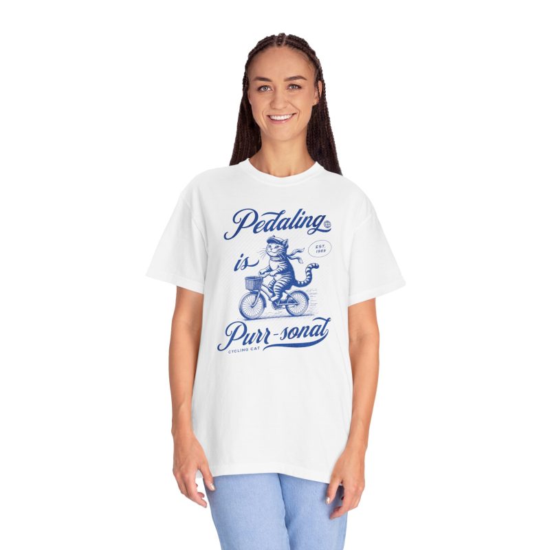 Person wearing a shirt with a blue cat on a bicycle
