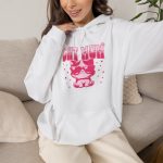 Person wearing a hoodie with a seated kitten in oversized sunglasses with pink striped lettering and stars printed on the front
