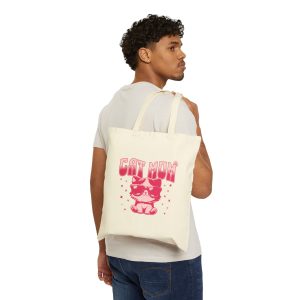 Person carrying a natural canvas tote with a seated kitten in oversized sunglasses with pink striped lettering and stars facing outward