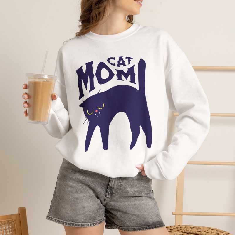 Person wearing a crewneck sweatshirt with a navy arched cat and wavy lettering graphic on the front