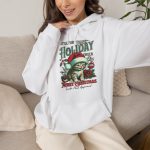 Person wearing a hoodie with a Santa-hat kitten with holly and an ornament graphic on the front
