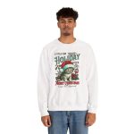Person wearing a crewneck sweatshirt with a Santa-hat kitten with holly and an ornament graphic on the front