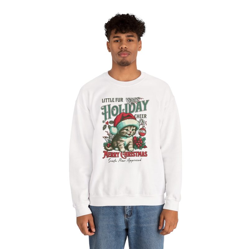 Person wearing a crewneck sweatshirt with a Santa-hat kitten with holly and an ornament graphic on the front