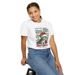 Person wearing a tee with a Santa-hat kitten with holly and an ornament graphic on the front