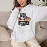 Person wearing a hoodie with a gray tabby in an orange coffee cup graphic on the front
