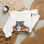 Detail of the gray tabby in an orange coffee cup graphic on the crewneck sweatshirt
