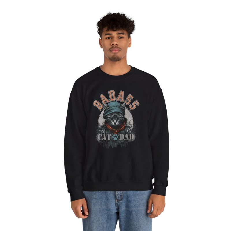 Person wearing a crewneck sweatshirt with a tabby in a cap, jacket and scarf graphic on the front