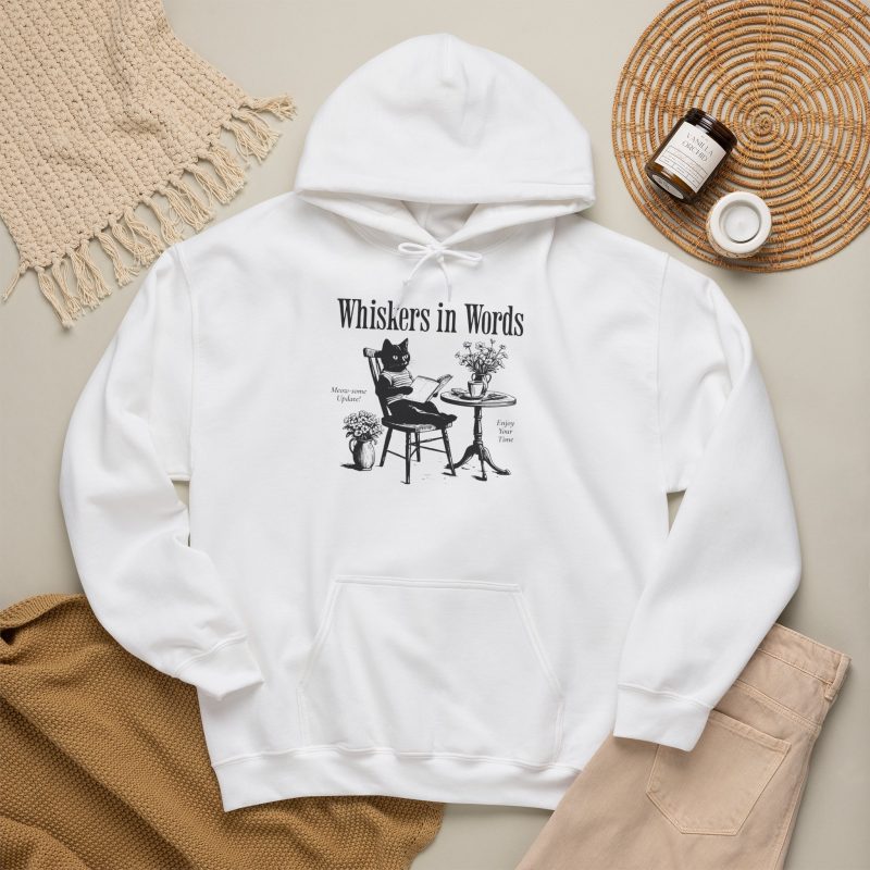 Detail of the cat reading a book at a café table graphic on the hoodie