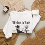 Detail of the cat reading a book at a café table graphic on the crewneck sweatshirt Detail of the cat reading a book at a café table graphic on the crewneck sweatshirt