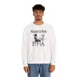 Person wearing a crewneck sweatshirt with a cat reading a book at a café table graphic on the front Person wearing a crewneck sweatshirt with a cat reading a book at a café table graphic on the front