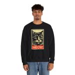 Person wearing a sweatshirt with a bold cat portrait and red panel