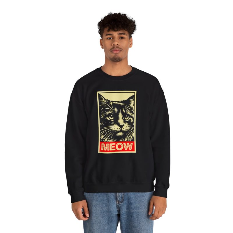 Person wearing a sweatshirt with a bold cat portrait and red panel