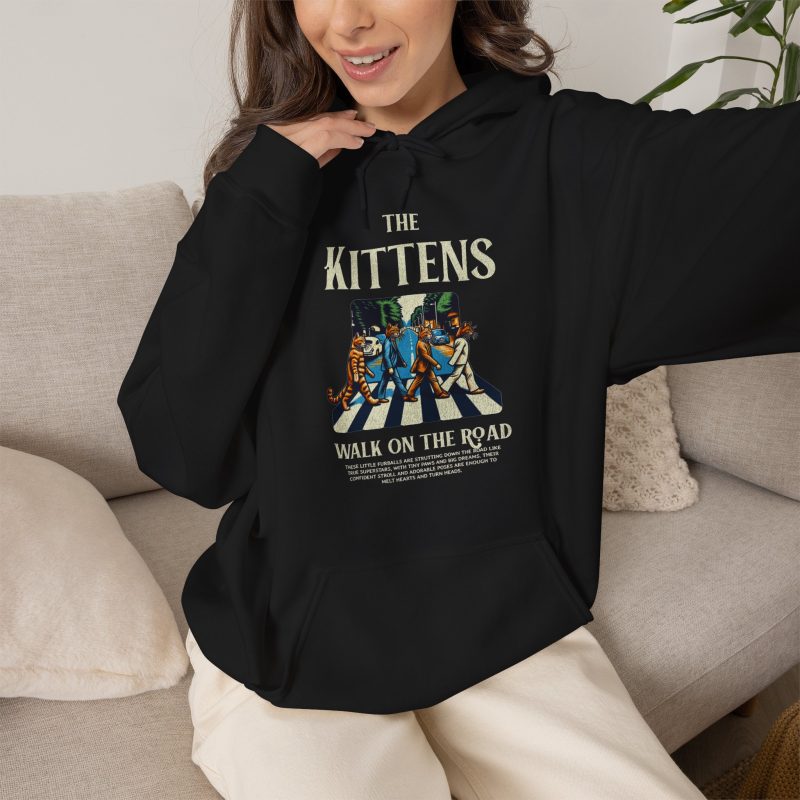 Person wearing a hoodie with crosswalk kittens