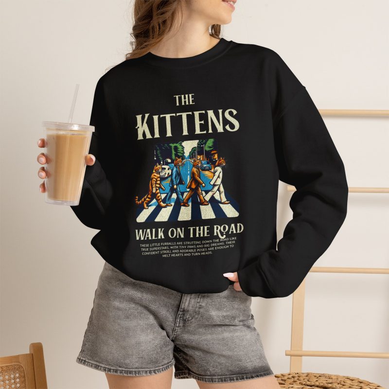 Person wearing a sweatshirt with crosswalk kittens