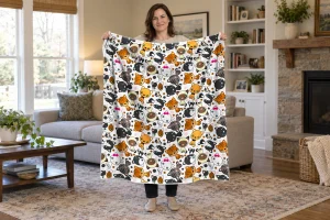Woman holding a full Kitties cat-pattern flannel blanket, with colorful cartoon kittens and polka dots repeated edge to edge on white.